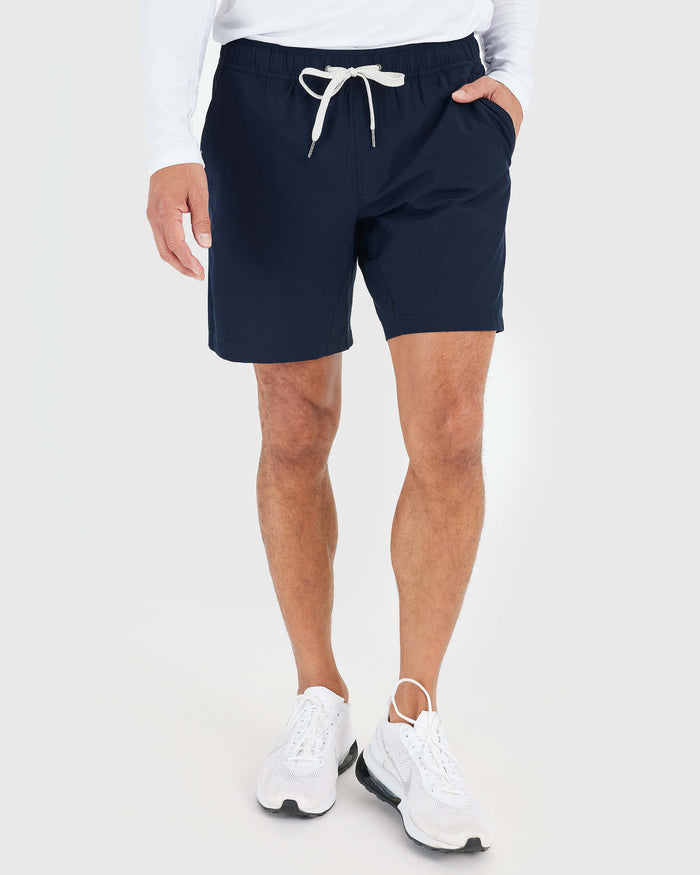 Model wearing Navy Active Quick Dry Shorts with Liner and white sneakers.