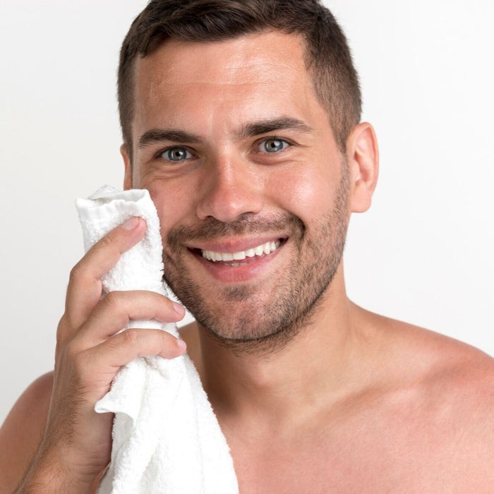 White man brown hair white towel in hand. Best anti-aging serum for face. Dermal Essentials Medical Grade Skincare.