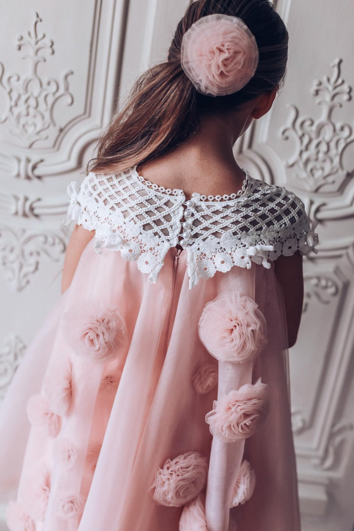 Back view of Rosa pink tulle flower hair clip worn in a ponytail highlighting layered tulle texture and soft  blush color