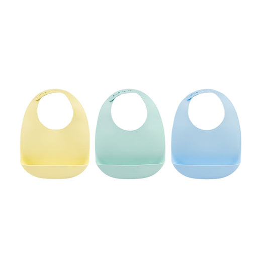 The Silicone Feeding Bib (3 Pack) | Yellow/Green/Blue is shown with three bibs side by side against a white background. The set includes yellow, mint green, and light blue bibs, each designed with an adjustable neck strap and a front pocket crumb catcher to catch food. These waterproof baby bibs help keep mealtime messes under control.