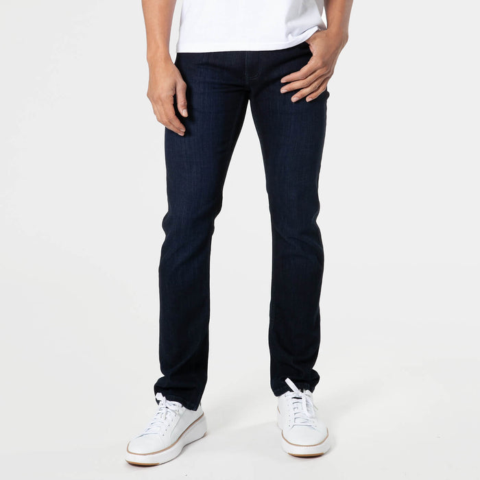 Man wearing dark indigo Slim Comfort Stretch Jeans 3-Pack paired with white sneakers and a white t-shirt, showcasing a comfortable, slim fit in casual men's basics style.