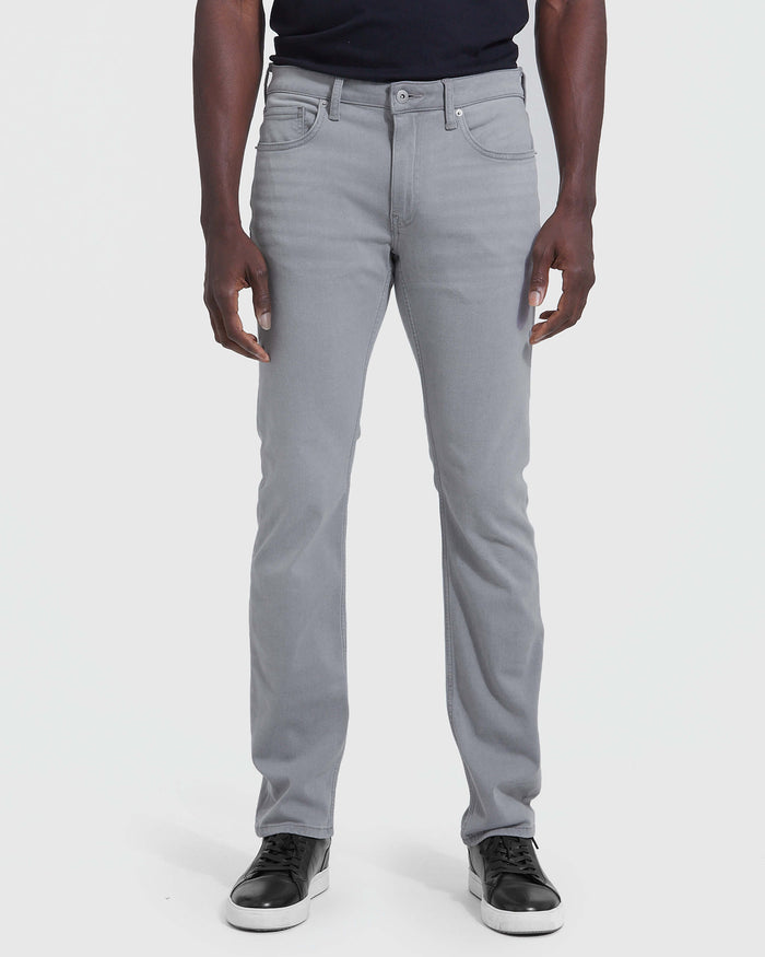 Front view of a man wearing gray Slim Comfort Stretch Jeans 3-Pack paired with black sneakers and a black shirt, showcasing a slim fit with a comfortable stretch for everyday wear.