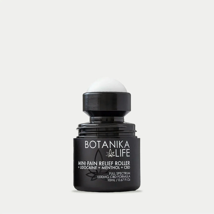 Black roller bottle labeled Botanika Life mini pain relief roller with lid off, showcasing a wellness device included in the Spafinder Travel Kit | Live Love Spa.