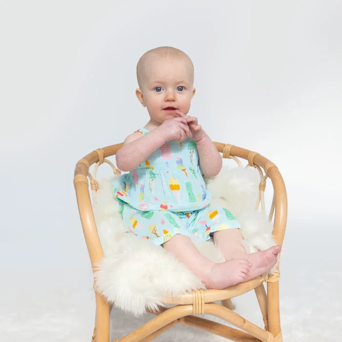 Baby wearing Angel Dear Fruit Dream Popsicles tie back romper in soft organic cotton muslin.