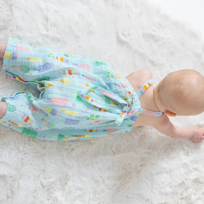 Baby lying in Angel Dear popsicle print muslin romper showing lightweight summer one-piece fit.