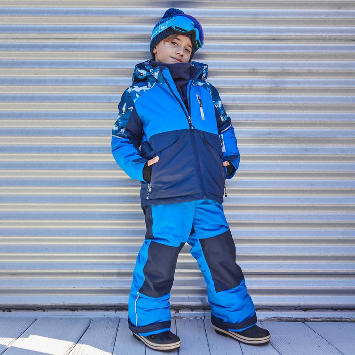 Boy wearing Deux par Deux Royal Blue penguin snowsuit for skiing, sledding, and winter play.