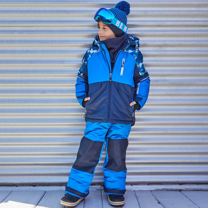 Side view of boy wearing Deux par Deux boys Royal Blue two-piece snowsuit with adjustable snow pants.