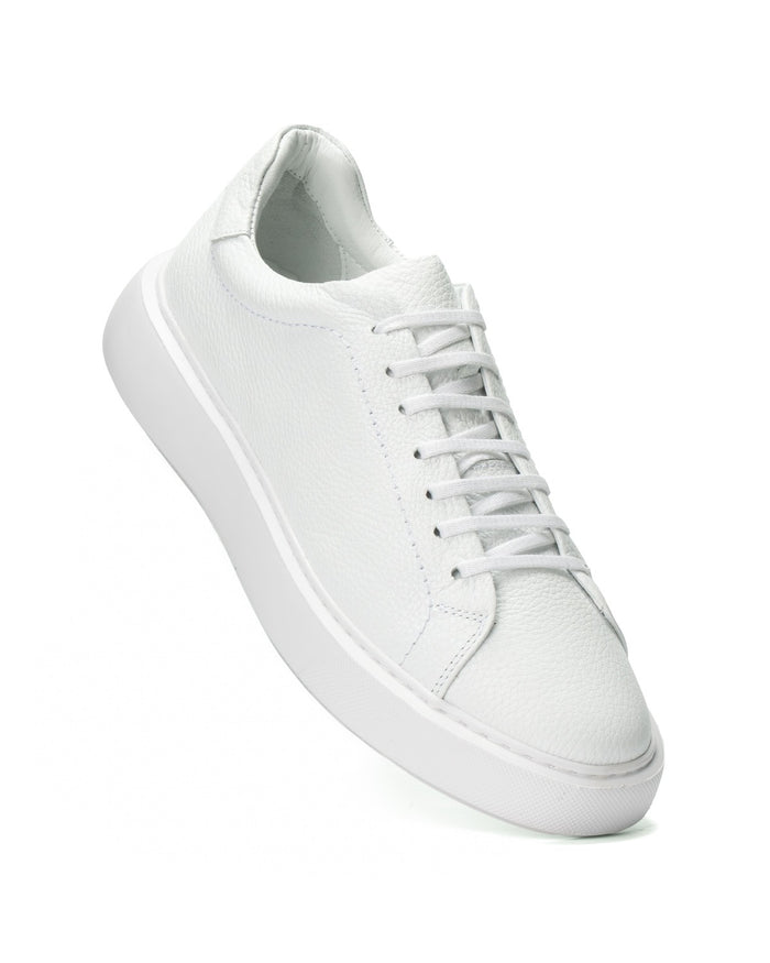 A single white leather low-top sneaker with matching white laces and a chunky white sole, shown at an angle on a clean white background.